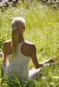 A girl meditating in a field on our Yoga Meditation Retreat Spain