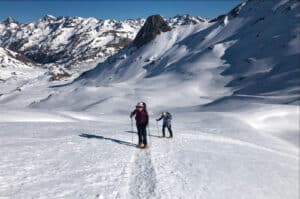 Two people walking in snow shoes in a pristine valley on our Snowshoeing Holidays Pyrenees