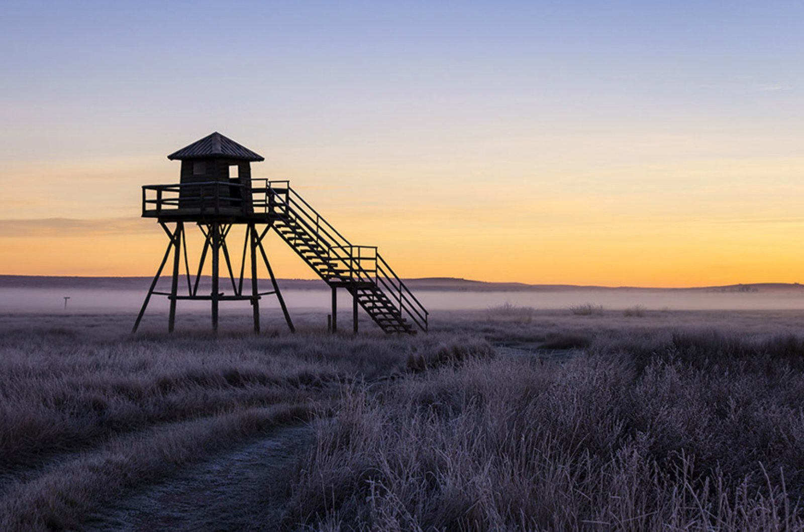 One of the elevated viewing platforms at Gallocanta as dawn breaks and a ground frost covers the grassland on Birding Holidays Spain with Aragon Active in the Spanish Pyrenees