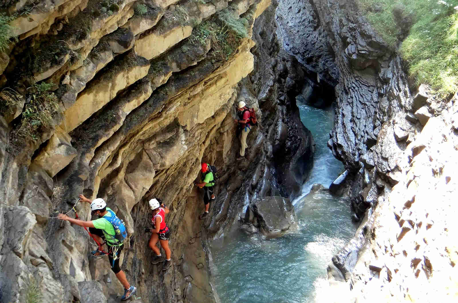 A group traversing a ledge on the via ferrata route in Broto just 2o minutes down the road from our Holiday Rental Torla-Ordesa