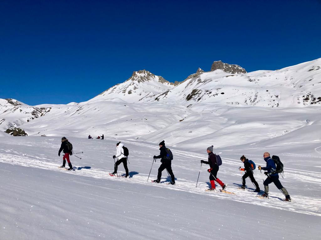 A group in a line snowshoeing through a snowy valley on our Snowshoeing Holiday Spain with Aragon Active small group holidays