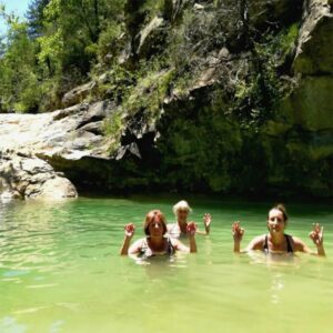 Three ladies swimming in a natural pool in the Spanish Pyrenees on our small group holidays with Aragon Active