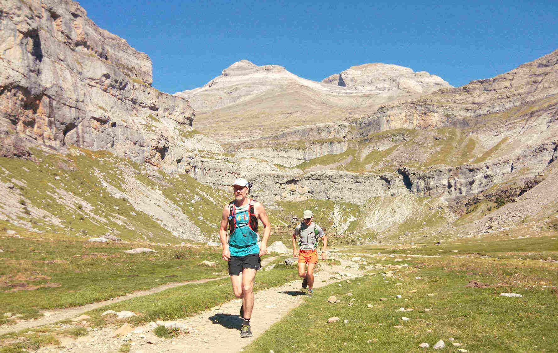 Two trail runners running in the bottom of the Ordesa valley in the Pyrenees on our Trail Running Holidays with Aragon Active small group holidays
