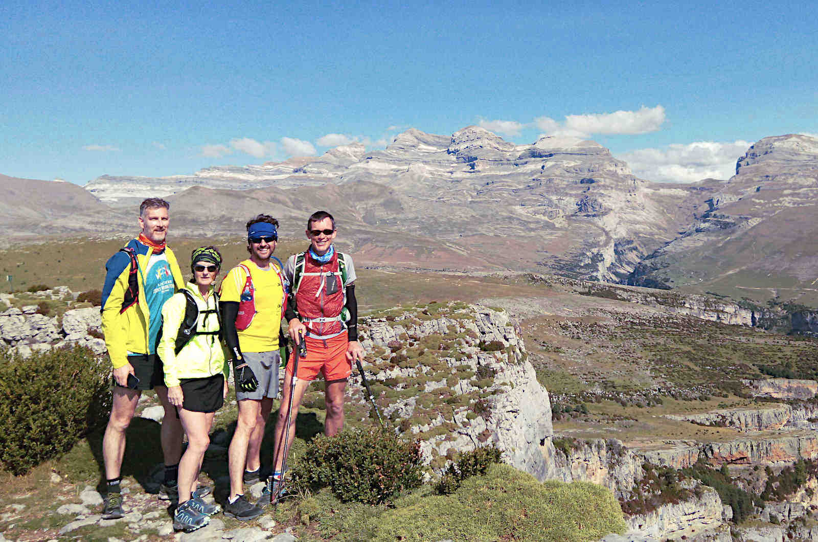 Four trail runners taking a quick break from running high up in the Pyrenees with panoramic views on our Trail Running Holidays with Aragon Active small group holidays