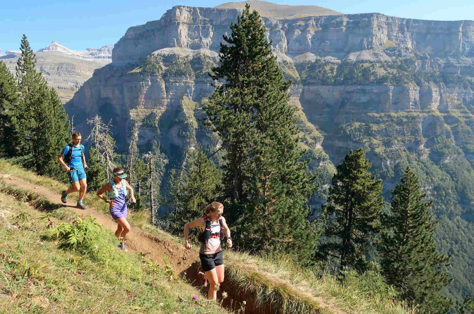 Three trail runners running high up on a faja or ledge in the Ordesa valley in the Pyrenees on our Trail Running Holidays with Aragon Active small group holidays