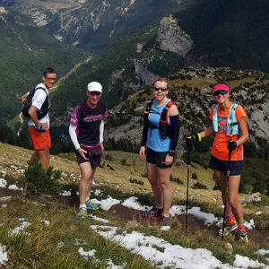Four trail runners stand for a photo on a mountain in the Pyrenees on our Trail Running Holidays with Aragon Active small group holidays