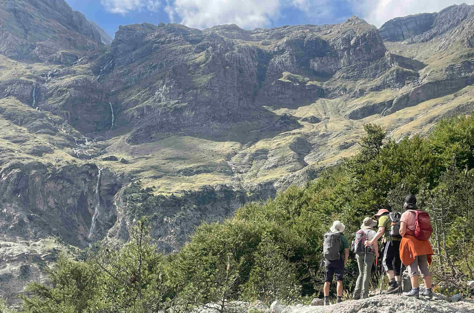A group of hikers with a guide stare up at the Cirque of mountains in front of them on Walking Holidays in Spain with Aragon Active