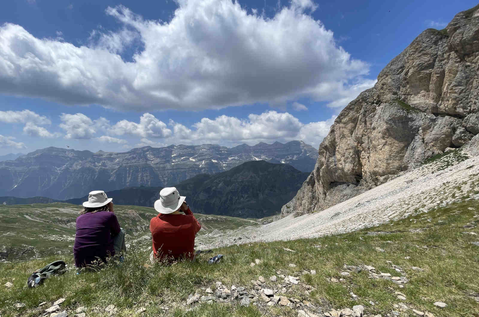 Two naturalists sitting in the mountains looking through binoculars on our Wildlife Holidays Spain with Aragon Active small group holidays