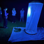 A group gathered around a moth trap at night illuminated with ultra-violet light on our Wildlife Holidays Spain with Aragon Active small group holidays in the Spanish Pyrenees